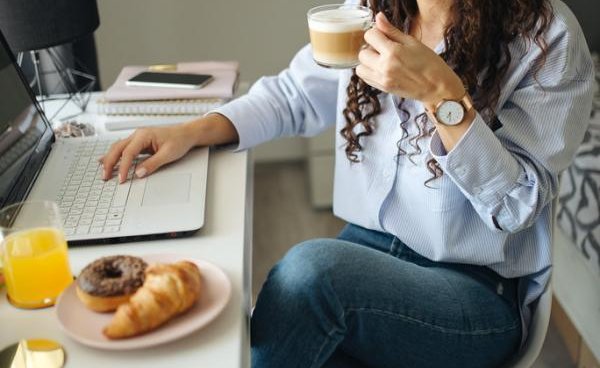 A woman reviewing her benefits on a laptop at home